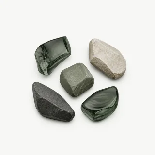 Five separate stone and glass forms arranged as a fragmented cluster